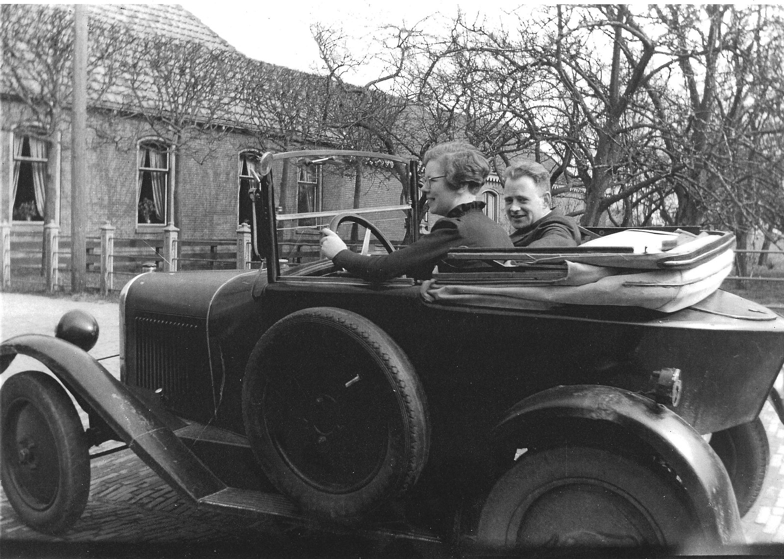 Annie Duin met haar latere man dhr. Hinke, in de auto waarmee stoffen bij klanten werden gebracht